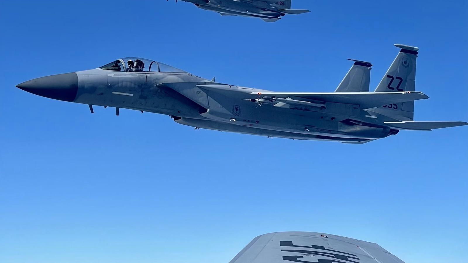 Two fighter aircraft holding position together in level flight at high altitude